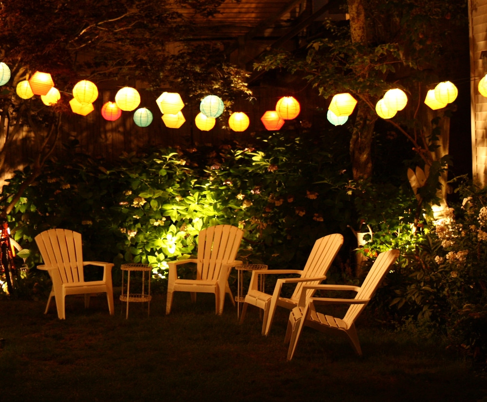 plastic garden chairs in a garden lit up at night