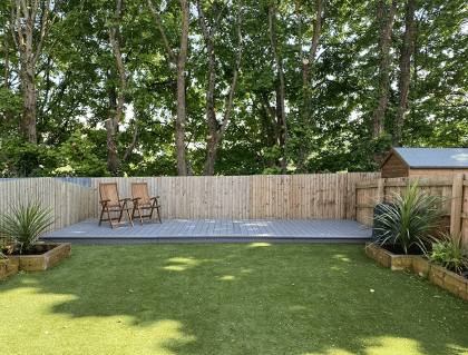 stunning renovated garden with clean cut grass and raised decking at the end of the plot