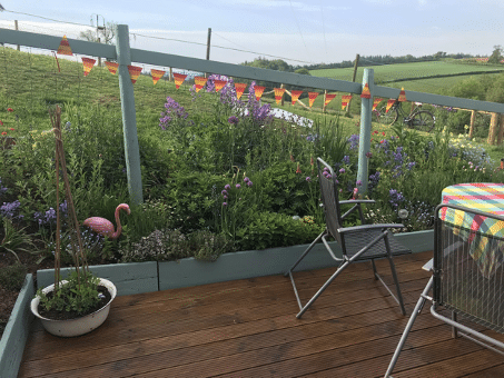 another view of the garden with planters and furniture sat on decking