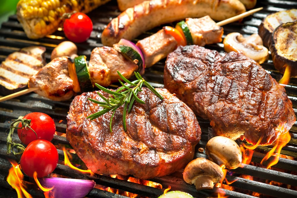 steak, skewers, sausages and veg on a hot grill