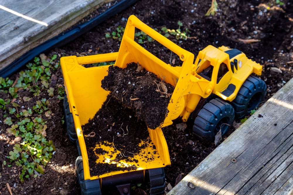 a toy truck used in a wooden planter