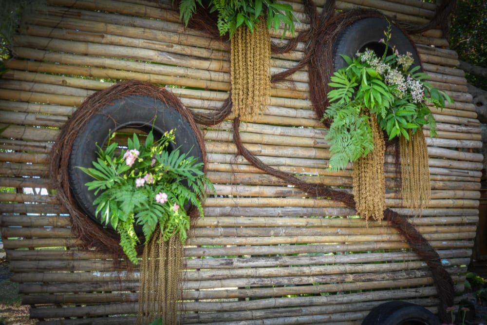 tyre planters hung from bamboo in a vertical garden