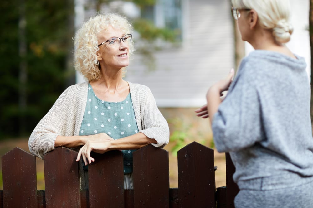 two older ladies chatting over fence