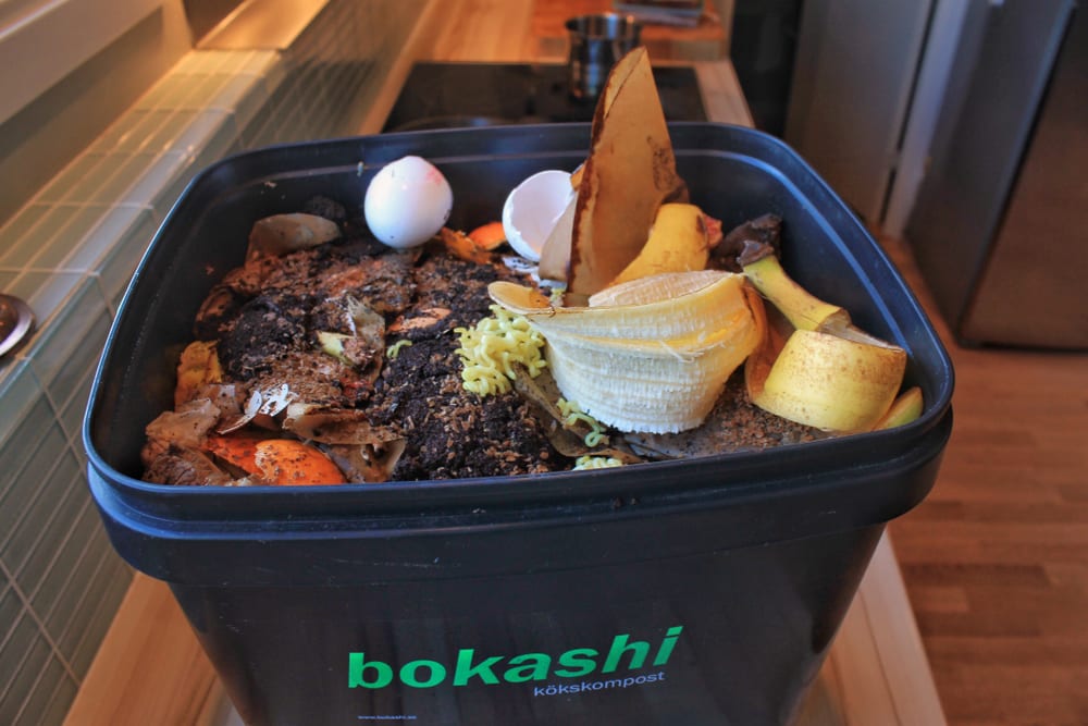 A bucket on a kitchen top filled with bokashi