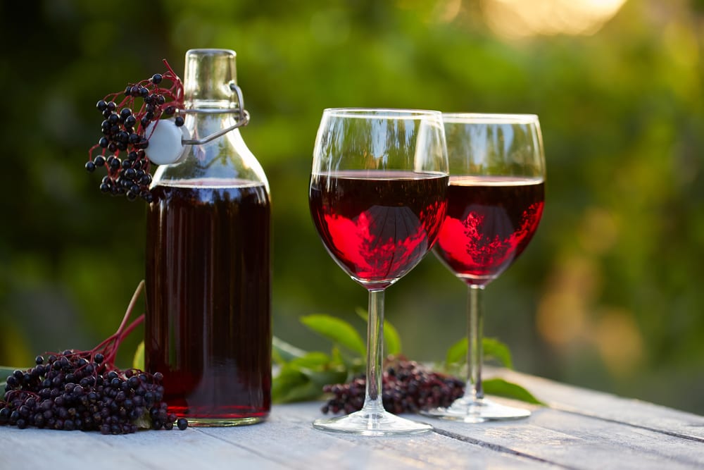 Glasses of elderberry wine on a wooden table